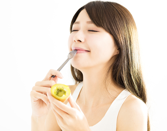 キウイを食べる女性